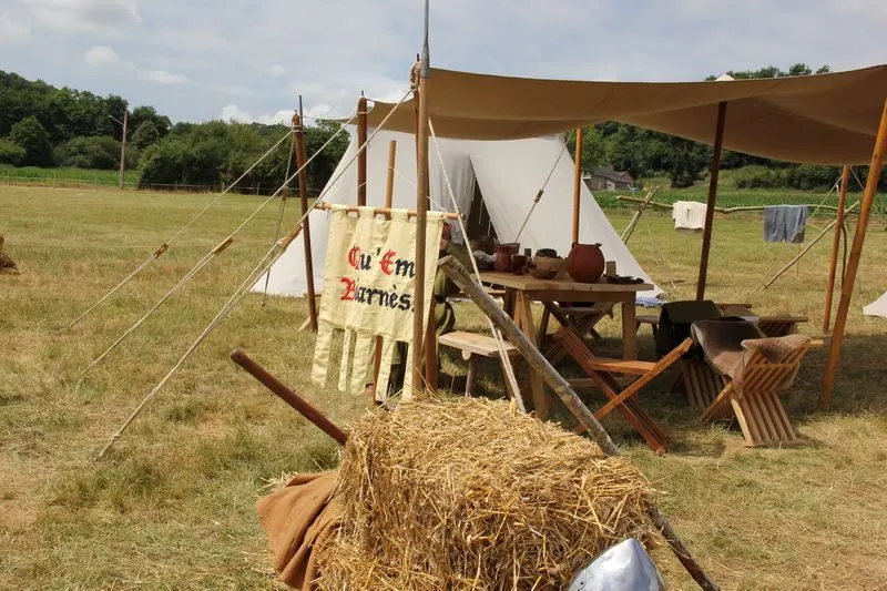 Campement m&eacute;di&eacute;val reconstitu&eacute; de Qu&rsquo;em Biarn&eacute;s avec tente, r&acirc;telier et paille